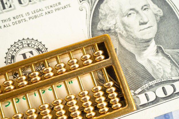A close-up shot of a calculator with a dollar sign imprinted on its screen, surrounded by stacks of coins and a partially visible newspaper headline about inflation and cost of living adjustments.