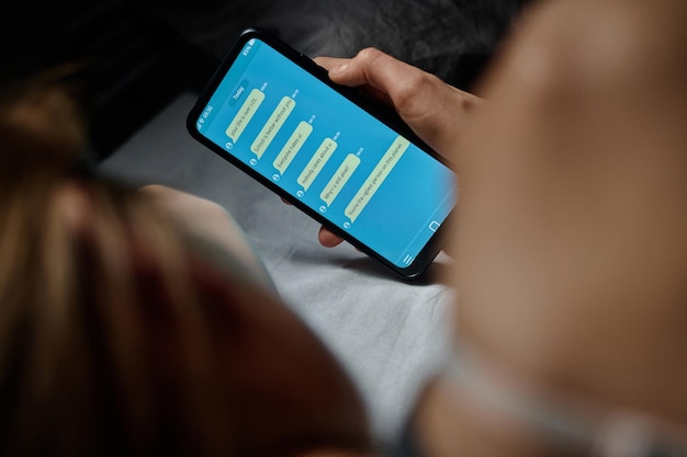 A person using a mobile banking app with charts showing growth in savings and investments.