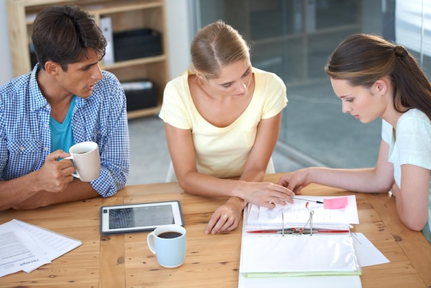 A close-up of an American family sitting around a table, reviewing financial documents and strategizing their estate planning. The image is brightly lit and conveys trust and careful consideration. Soft focus on the background to emphasize the family/advisor interaction.