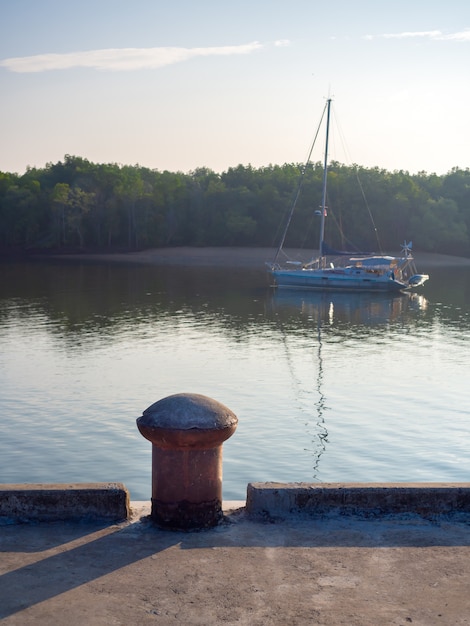 A calm harbor with boats gently bobbing on the water, symbolizing stability and resilience in investing. A lighthouse stands tall and strong in the background, representing guidance and security in financial decisions.