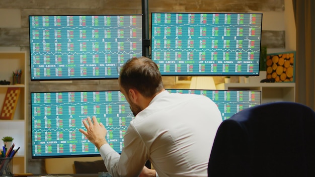 An image depicting traders in a stock exchange, intently observing market data on multiple screens showing bond prices and yield curves in real-time.