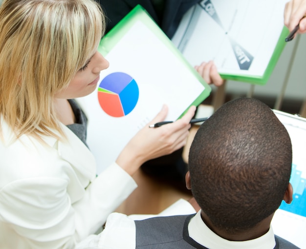 A split-screen image showing analytical charts on one side and a group of people brainstorming in a meeting room on the other, connected by visual arrows labeled 