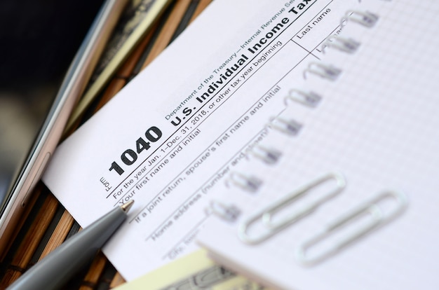 A close-up of a U.S. tax form (Form 1040) with a highlighted section showing the Earned Income Tax Credit (EITC) line. A pen is placed on top of the form, suggesting careful review and preparation. The background is blurred, focusing attention on the EITC section of the form.