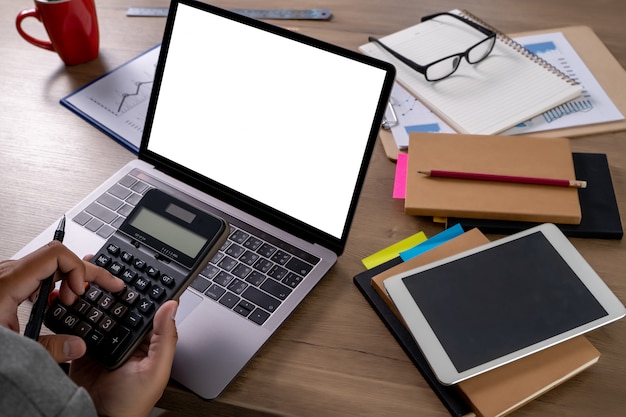 A person working on a laptop, surrounded by tax documents and a calculator. The screen displays the IRS website with the EITC section highlighted. The image represents the process of researching and preparing to claim the Earned Income Tax Credit.