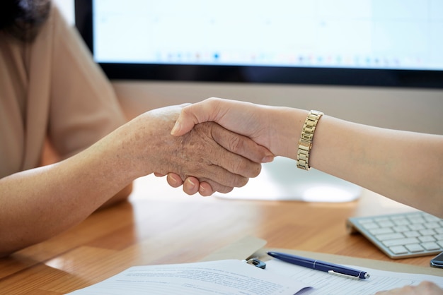 A close-up shot of two hands shaking, symbolizing an agreement between an employee and employer regarding retirement benefits.