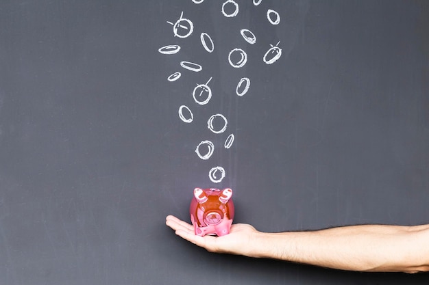 A person putting coins into a piggy bank, with a 401(k) statement in the background, symbolizing consistent savings and planning.