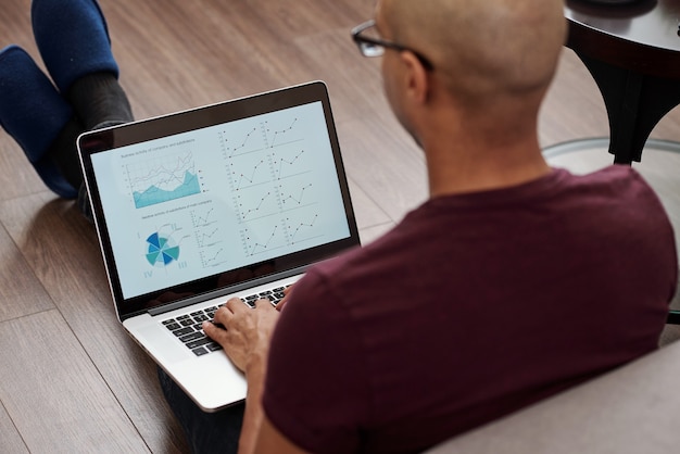 A person using a laptop to review their investment portfolio, with charts and graphs related to bond yields and fixed income returns visible on the screen.