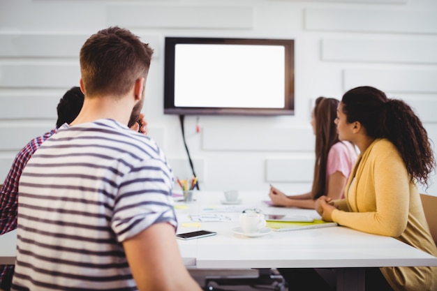 A split-screen image. On one side, a classroom setting with students participating in a job training program. On the other side, construction workers building a new highway, representing infrastructure investment.