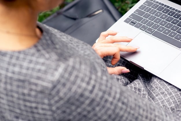 A close-up shot of a person's hands using a laptop to compare different HSA provider websites. The screen shows various HSA features, fee structures, and investment options. The setting is a home office with plants and a cup of coffee in the background.