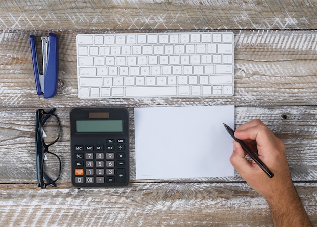 A person using a calculator, with tax forms and financial documents spread out on the table, showing the planning and calculation needed for taxes on social security benefits.